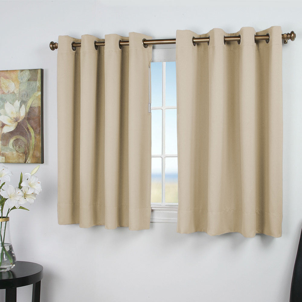 Ivory Ultimate Blackout Grommet Top Shortie Panels hanging on a decorative curtain rod 